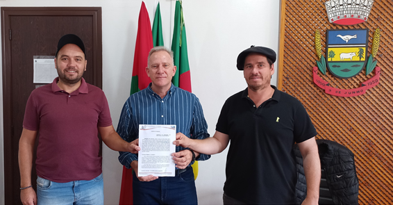 Guilherme Amado e Talisson Mion, da Plantar Assessoria Rural, recebendo do prefeito Gelson Scherer o Termo de Concessão de Uso de Imóvel