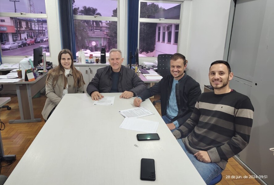 Prefeito Gelson no ato da assinatura da ordem, juntamente com a pregoeira Keith e os responsáveis da licitante vencedora.